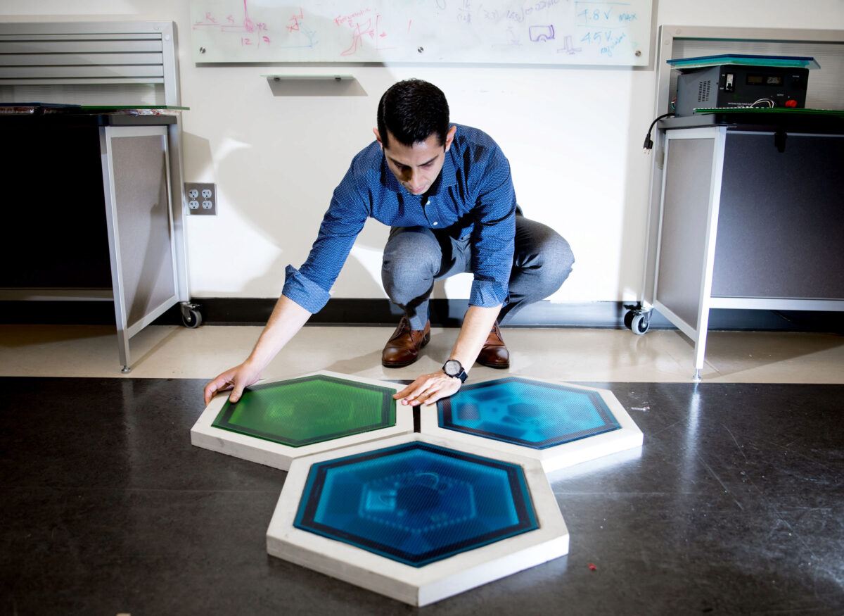Ilan Stern, a GTRI senior research scientist, shows piezoelectric tiles that will be used to create a lighted outdoor footpath at the NASA Kennedy Space Center’s Visitor Complex at Cape Canaveral, Florida. He’s holding the electronic components used in th