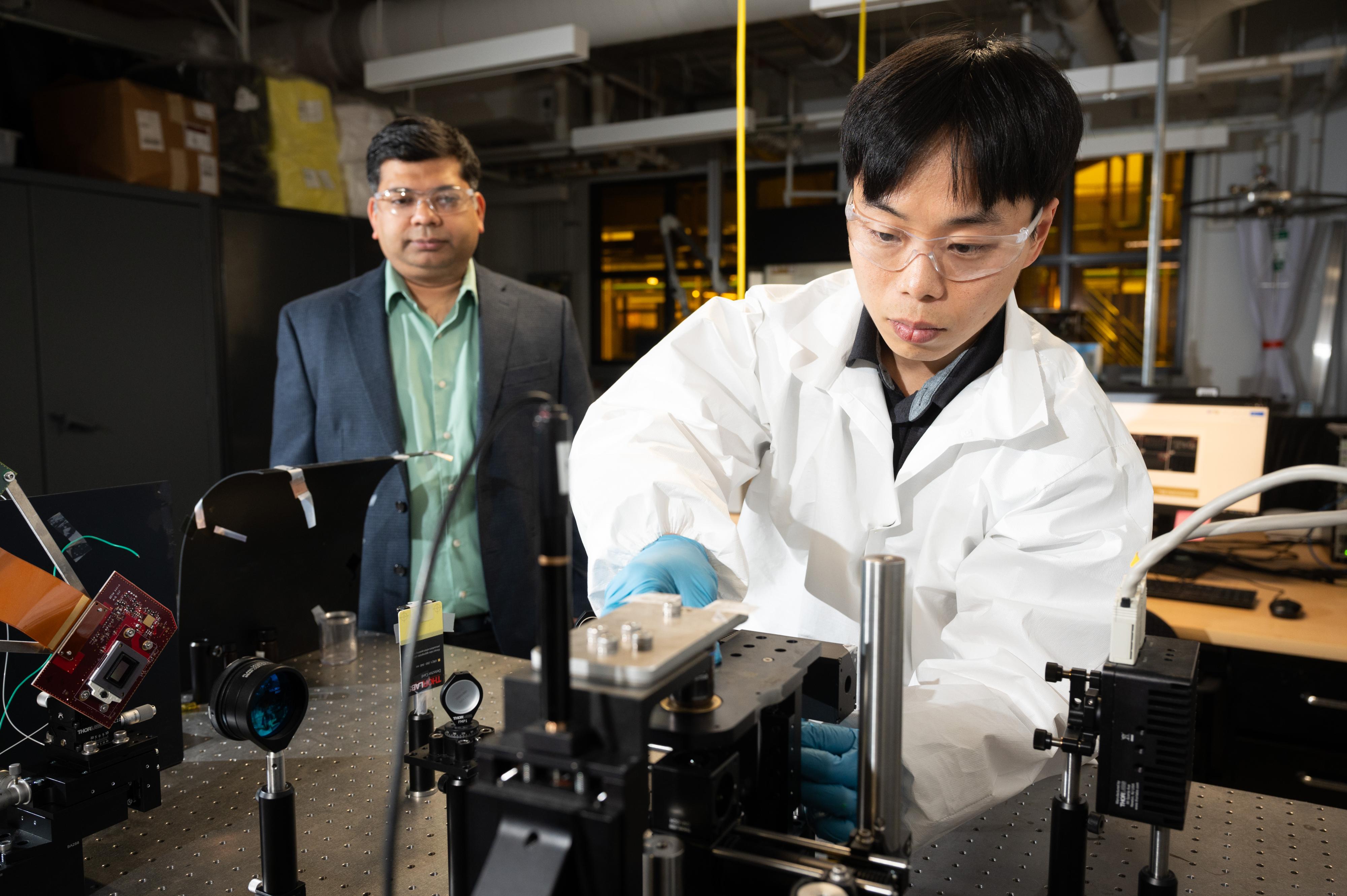 Choi (right) carries out optical adjustment for the correct focal plane of the SLP system.