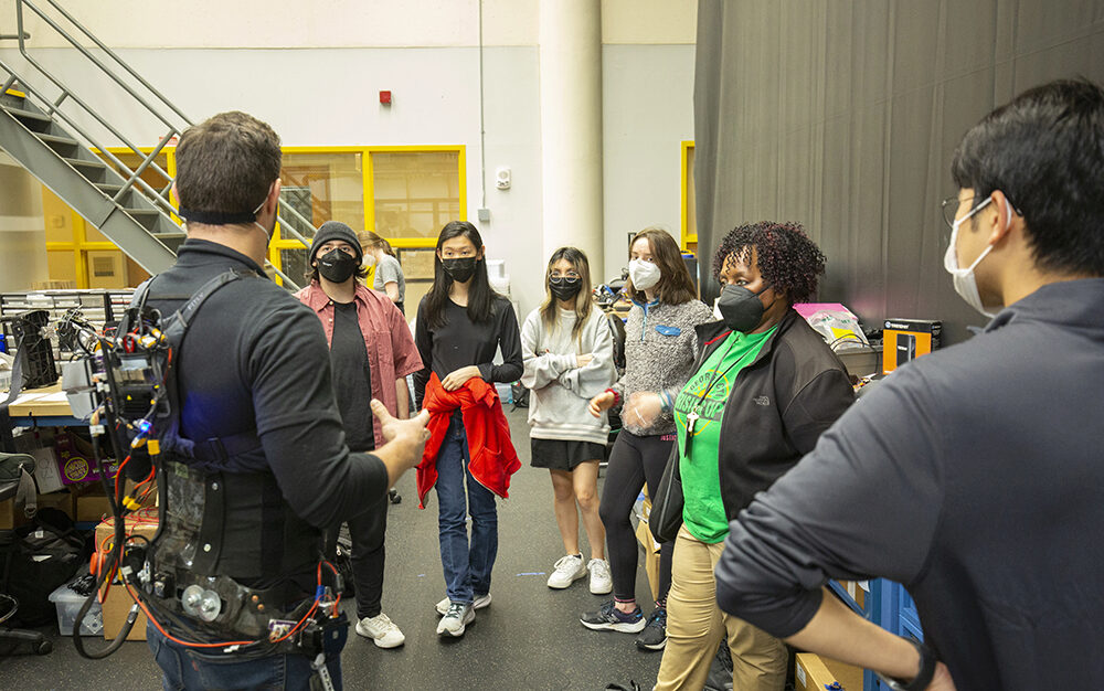 Students learning about a hip exoskeleton from Ph.D. student Dean Molinaro.