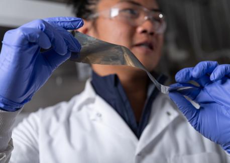 Graduate student researcher Yuhgene Liu holds an aluminum material for solid-state batteries.