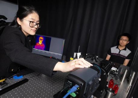 Postdoctoral scholar Dingding Han adjusts a thermal camera capturing an image of Ph.D. student Corey Zheng.