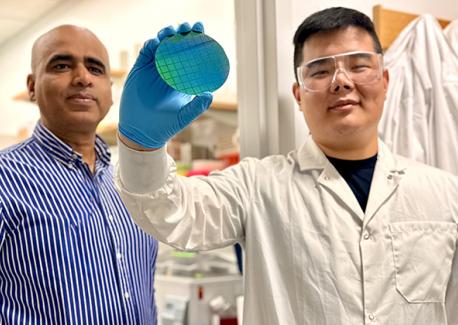 Ankur Singh, left, and Zhonghao (Eric) Dai in the Immunotherapy and Cell Engineering laboratory at the Georgia Institute of Technology. Dai holds a silicon nanowire wafer manufactured as part of a revolutionary effort to reverse aging in human immune cells.